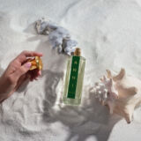 Bellekin ANNI parfum fles ligt op het strand met een schelp
