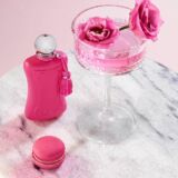 Parfums de Marly Oriana roze parfumfles op marmeren tafel met roze cocktail met bloemen en een macaron erbij