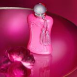 Parfums de Marly Oriana roze Parfumfles op een roze tafel met een bloem