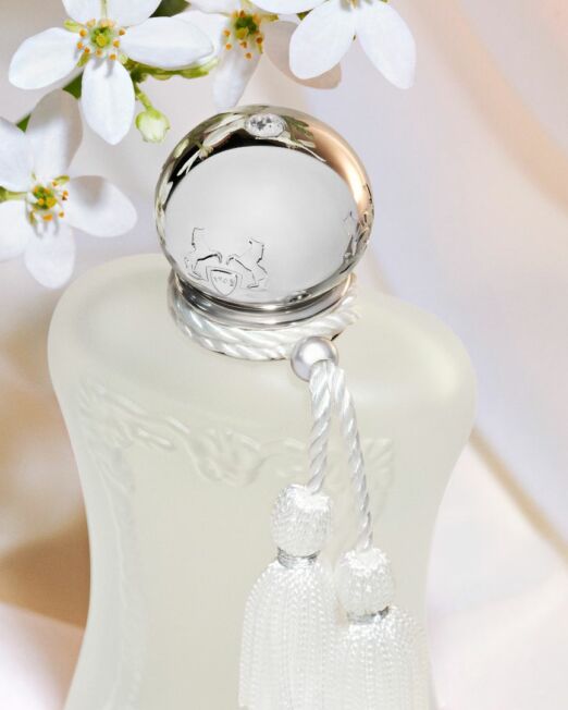 Parfums de Marly Valaya parfum fles van close up met een tak met witte bloemen