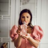 Vrouw houd Parfums de Marly Delina La rosee parfumfles vast in haar handen