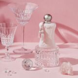 Parfums De Marly Delina Exclusif staat op een tafel met roze tafelkleed met erop diamanten