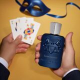 Parfums de Marly Layton Exclisif blauwe parfumfles met twee paarden erop en een zilveren dop tijdens een kaartenspel
