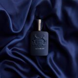 Parfums de Marly Layton Exclisif blauwe parfumfles met twee paarden erop en een zilveren dop liggend op blauw satijnen doek